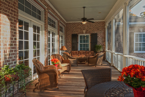 Screened in sunroom with wood floors and brick walls