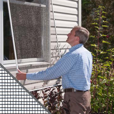 Man installing a complete window screen onto his home