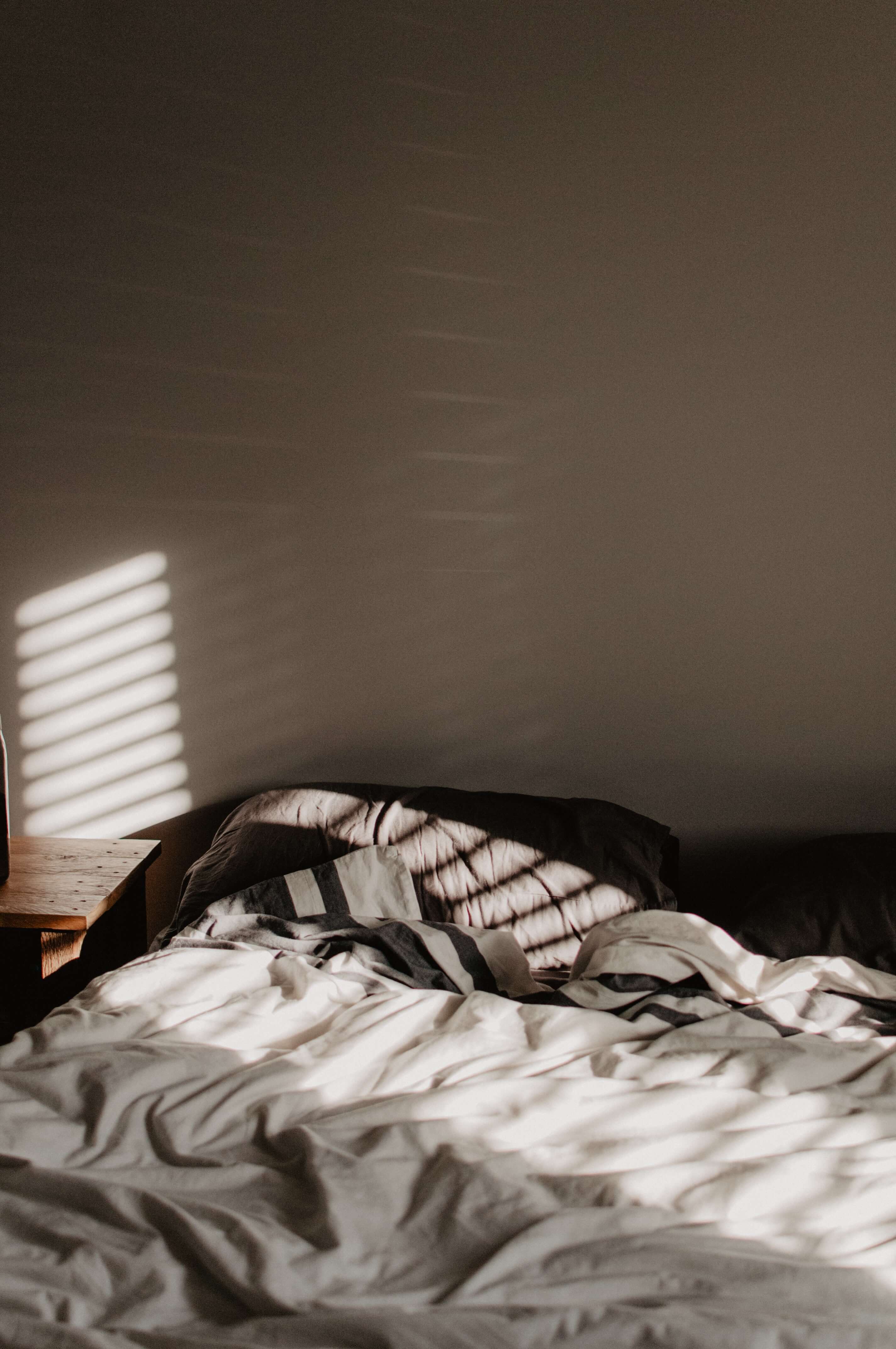 Bed with light peering through window